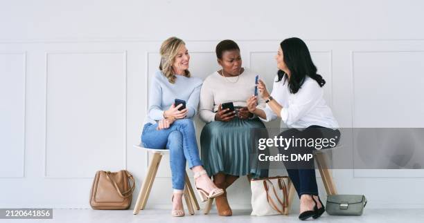 diversity, networking and women in waiting room with phone, talking or social media connection at recruitment agency. technology, opportunity and friends at job interview together with smartphone - interview icon stock pictures, royalty-free photos & images