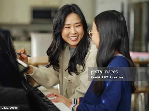 piano teacher and student in a home - korean daughter melody stock pictures, royalty-free photos & images