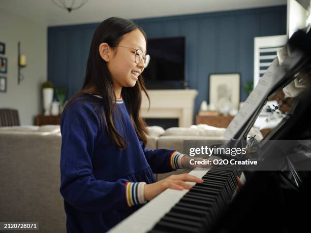 young girl practicing piano in a home - keyboard player stock pictures, royalty-free photos & images