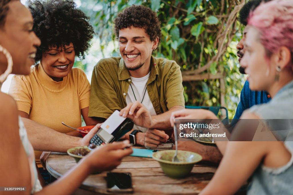 Group of friends contactless payment with credit card