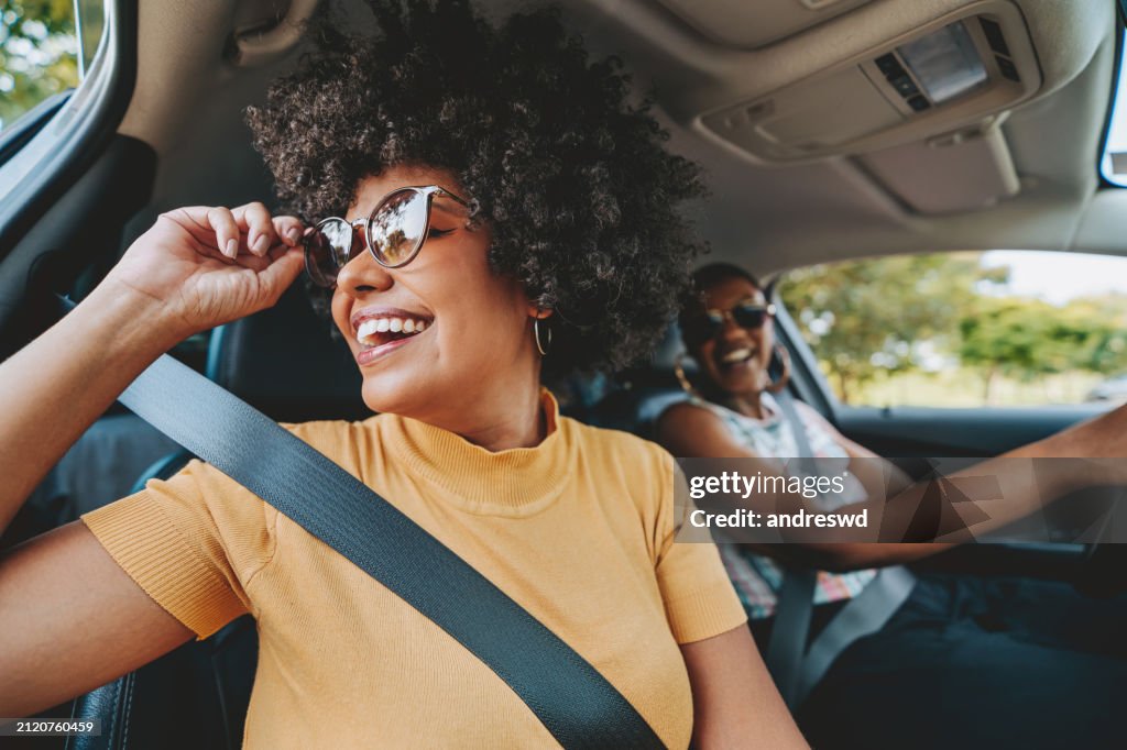 Happy friends traveling by car