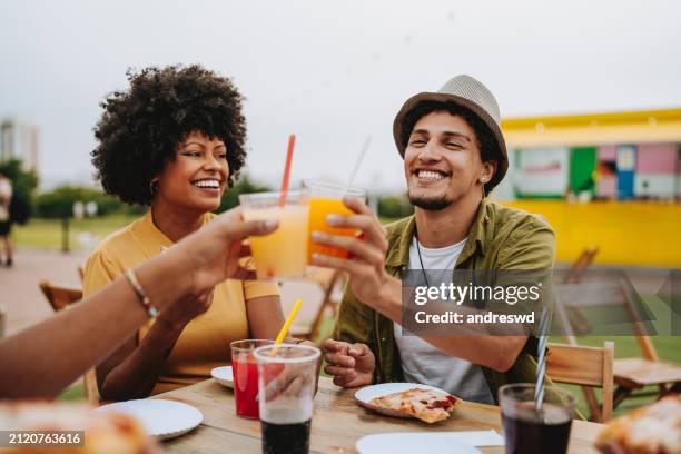friends toasting with drink sitting at outdoor table in restaurant - cold drink stock pictures, royalty-free photos & images
