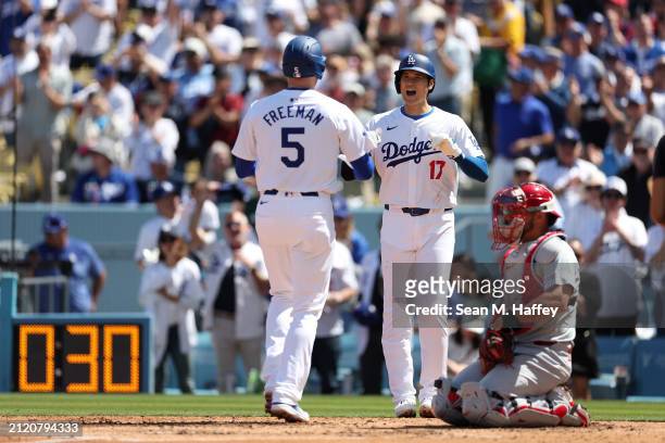 Shohei Ohtani congratulates Freddie Freeman of the Los Angeles Dodgers connects at the plate after his two-run homerun during the third inning of a...