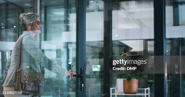 business, office and woman at night walking with bag to leave and exit workplace in london. corporate, professional and employee at front door in dark modern building for late work, shift and commute - deur stockfoto's en -beelden
