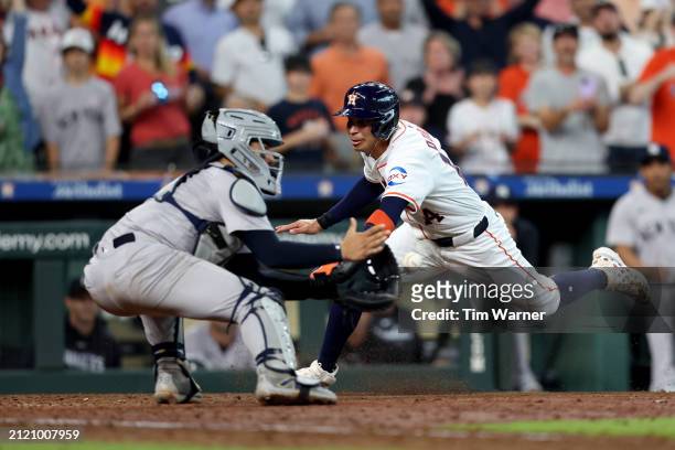 Mauricio Dubon of the Houston Astros is out at the plate in the ninth inning against Jose Trevino of the New York Yankees on Opening Day at Minute...