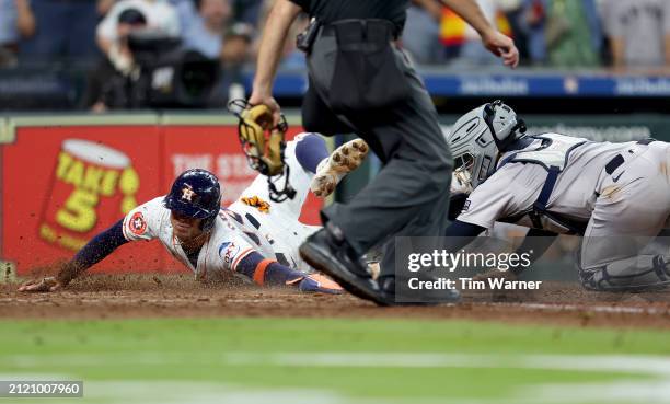 Jose Trevino of the New York Yankees tags out Mauricio Dubon of the Houston Astros at the plate in the ninth inning on Opening Day at Minute Maid...