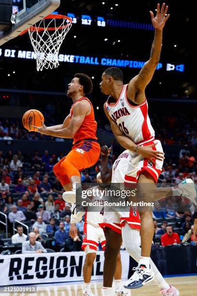 Chase Hunter of the Clemson Tigers lays up against Keshad Johnson of the Arizona Wildcats during the first half in the Sweet 16 round of the NCAA...