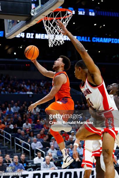 Chase Hunter of the Clemson Tigers lays up against Keshad Johnson of the Arizona Wildcats during the first half in the Sweet 16 round of the NCAA...