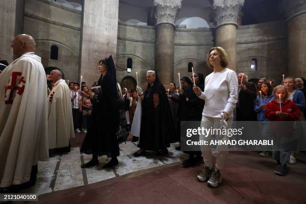 Clergymen and Christian worshippers circle around the Edicule, traditionally believed to be the burial site of Jesus Christ, at the Church of the...