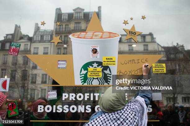 Woman writes complicit, boycott on a Starbucks at the demonstration in support of the Palestinian people in Paris, France on March 30, 2024....