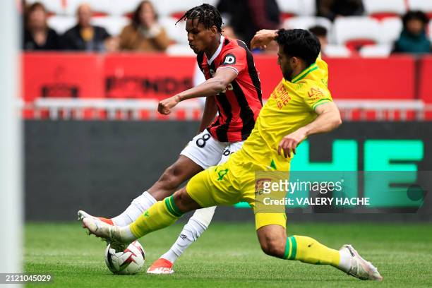 Nice's Algerian defender Hicham Boudaoui fights for the ball with Nantes' Swiss defender Eray Ervin Comert during the French L1 football match...