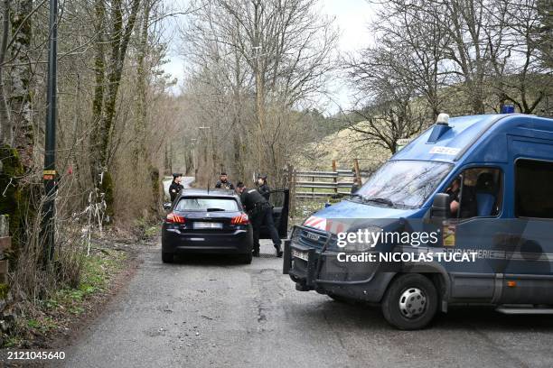 French Gendarmes inspect a car on the road to the French southern Alps tiny village of Le Haut-Vernet, in Le Vernet on March 31 after French...