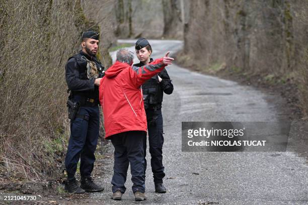 French Gendarmes discuss with a resident of Le Vernet, on the road to the French southern Alps tiny village of Le Haut-Vernet, in Le Vernet on March...