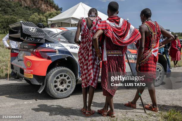 Maasai men stand in front the Hyundai i20 N Rally1 Hybrid of Finnish driver Esapekka Lappi and Finnish co-driver Janne Ferm at the finish lane of the...