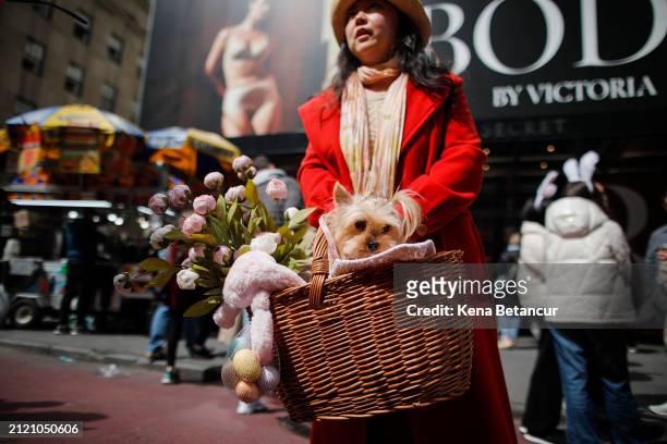 Woman carries a Dog as People participate in the Easter parade outside Saint Patrick's Cathedral on March 31, 2024 in New York City. Every year...