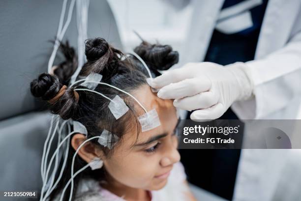 doctor preparing a child patient to do polysomnography at medical clinic - eeg stockfoto's en -beelden