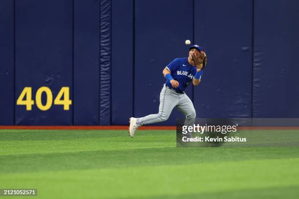 Daulton Varsho of the Toronto Blue Jays catches a fly ball during the fourth inning against the Tampa Bay Rays at Tropicana Field on March 31, 2024...