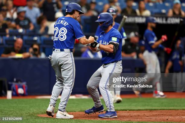 Davis Schneider of the Toronto Blue Jays celebrates with Ernie Clement after hitting a home run during the fifth inning against the Tampa Bay Rays at...