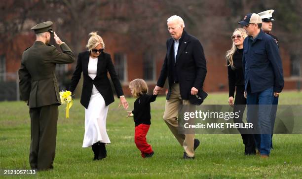 Marine escort salutes as US President Joe Biden walks with grandson Beau and first lady Jill Biden as son Hunter Biden walks with his wife Melissa,...