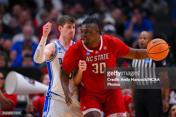 Burns Jr. #30 of the North Carolina State Wolfpack backs down Kyle Filipowski of the Duke Blue Devils during the Elite Eight round of the 2024 NCAA...