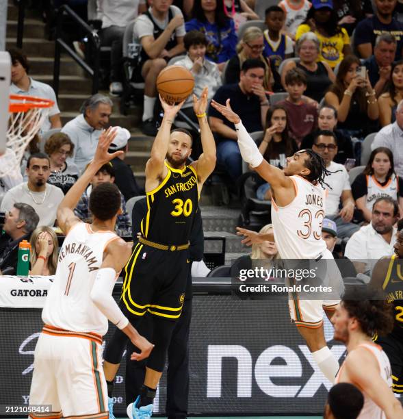 Stephen Curry of the Golden State Warriors hits a three by Tre Jones of the San Antonio Spursin the first half at Frost Bank Center on March 31, 2024...