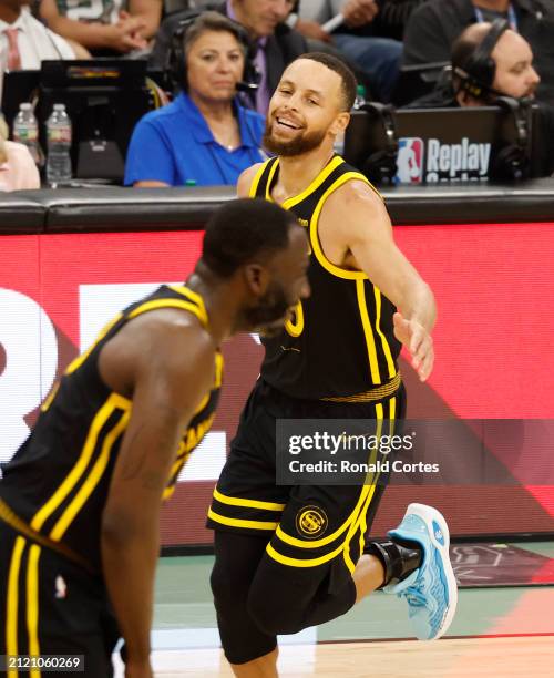 Stephen Curry of the Golden State Warriors slaps hands with Draymond Green after hitting a three-pointer against the San Antonio Spurs in the second...