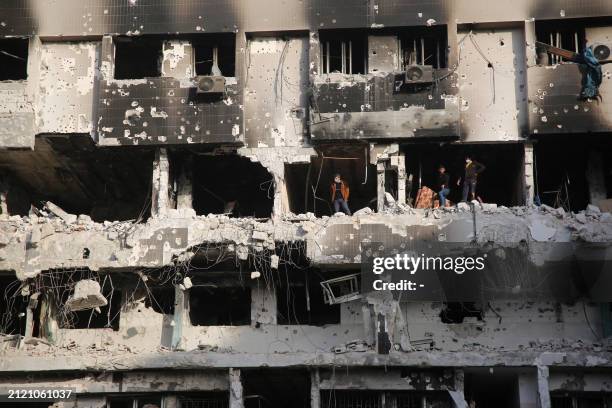 Palestinians inspect the damage at Gaza's Al-Shifa hospital after the Israeli military withdrew from the complex housing the hospital on April 1 amid...