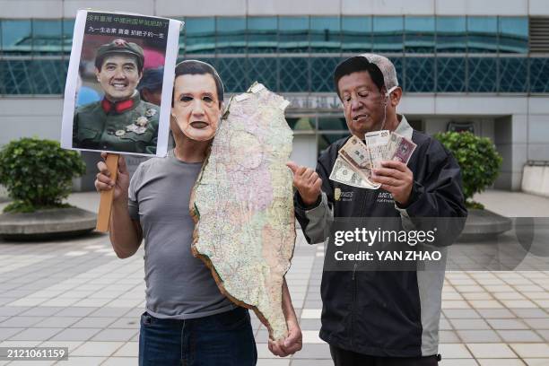 Pro-Taiwan independence activists, one wearing a cutout face mask of China's President Xi Jinping and carrying banknotes while the other wearing a...