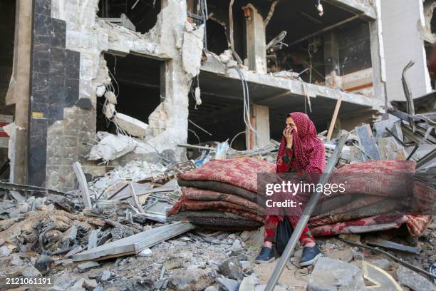 Palestinian woman reacts as she sits amidst the rubble of Gaza's Al-Shifa hospital after the Israeli military withdrew from the complex housing the...