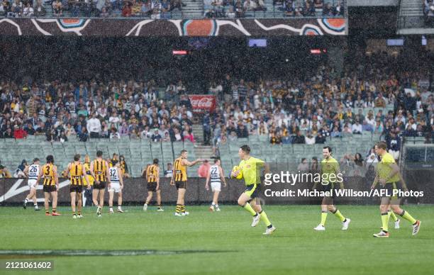 Umpire Nick Foot calls a pause in play due to nearby lightning strikes during the 2024 AFL Round 03 match between the Hawthorn Hawks and the Geelong...