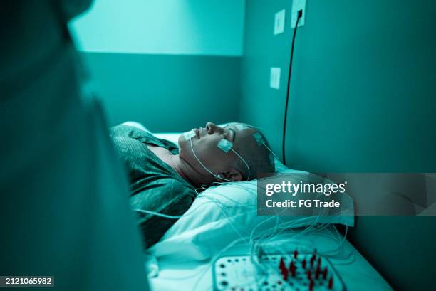 eine reife frau, die gegen krebs kämpft, macht polysomnographie - eeg stock-fotos und bilder