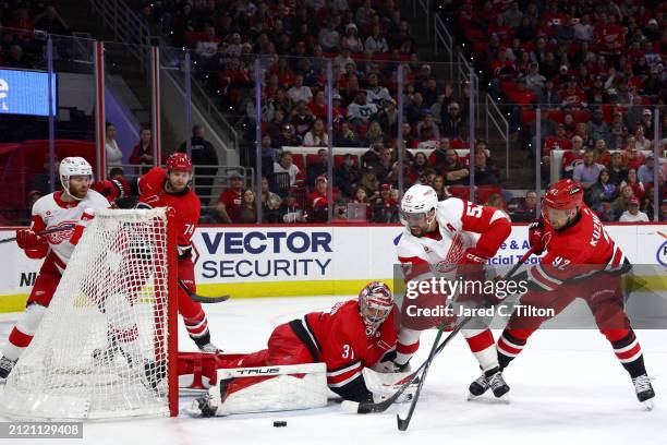 Frederik Andersen of the Carolina Hurricanes makes a save against David Perron of the Detroit Red Wings during the first period of the game at PNC...