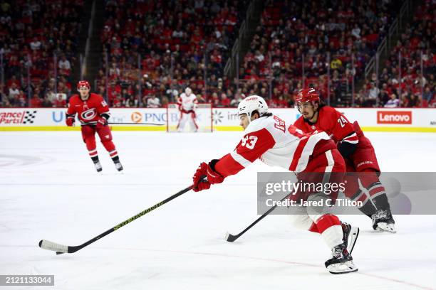 Alex DeBrincat of the Detroit Red Wings skates with the puck during the first period of the game against the Carolina Hurricanes at PNC Arena on...