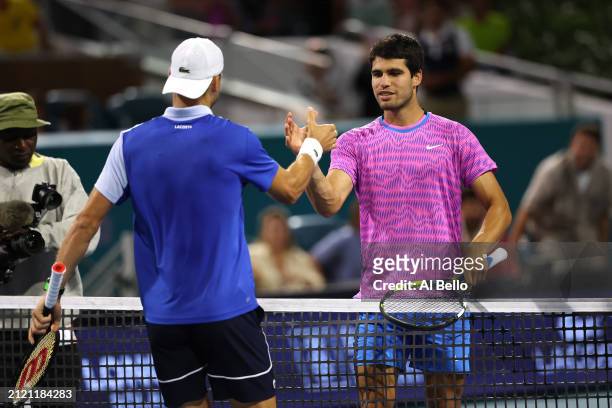 Grigor Dimitrov of Bulgaria meets Carlos Alcaraz of Spain at the net after defeating him on Day 13 of the Miami Open at Hard Rock Stadium on March...