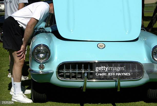 Corvette enthusiast looks into the hood of a 1957 roadster on display at the Bloomington Gold Corvette show 27 June, 2003 in St Charles, IL. The...