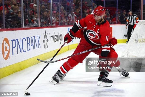 Jordan Staal of the Carolina Hurricanes protects the puck from Justin Holl of the Detroit Red Wings during the second period of the game at PNC Arena...