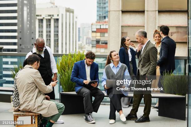 wide shot business colleagues in discussion on rooftop deck of office - wide shot stock pictures, royalty-free photos & images