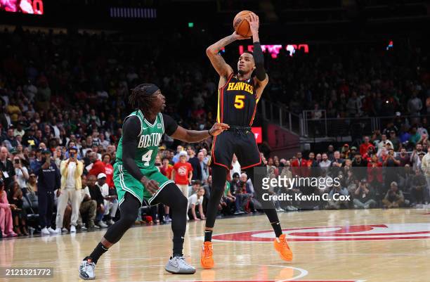 Dejounte Murray of the Atlanta Hawks hits the game-winning basket against Jrue Holiday of the Boston Celtics during overtime at State Farm Arena on...