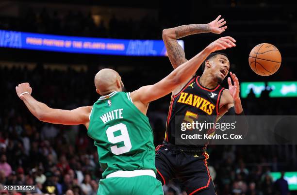 Derrick White of the Boston Celtics knocks the ball away from Dejounte Murray of the Atlanta Hawks during overtime at State Farm Arena on March 28,...