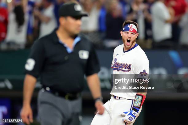 Jonah Heim of the Texas Rangers celebrates a walk-off single in the 11th inning to defeat the Chicago Cubs in the Opening Day game at Globe Life...