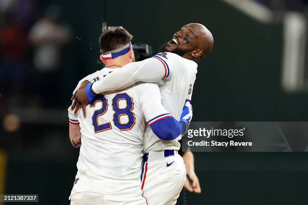 Jonah Heim of the Texas Rangers is congratulated by Adolis Garcia following a walk-off single in the 11th inning to defeat the Chicago Cubs in the...