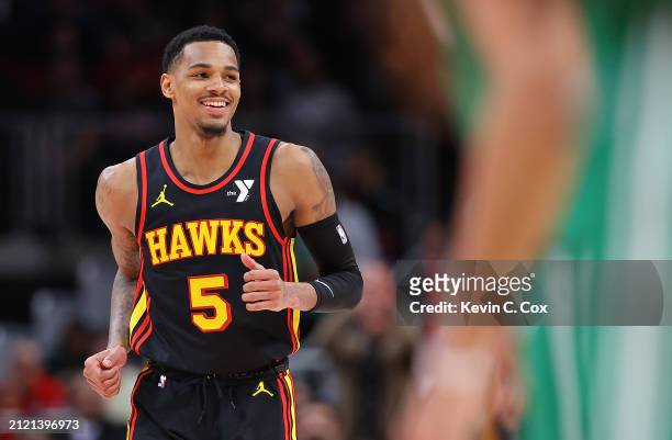 Dejounte Murray of the Atlanta Hawks reacts after a basket against Kristaps Porzingis of the Boston Celtics during overtime at State Farm Arena on...