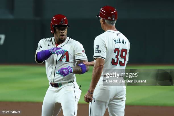 Ketel Marte of the Arizona Diamondbacks celebrates a base hits a with Dave McKay against the Colorado Rockies in the third inning at Chase Field on...