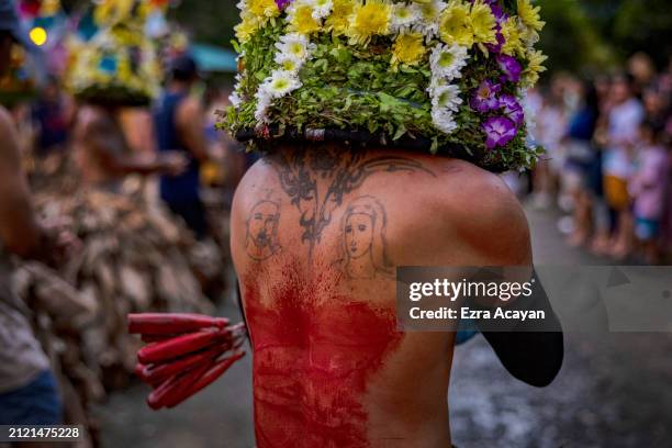 Tattoo of Jesus Christ and Mother Mary is seen in the bloodied back of a flagellant during Good Friday Lenten Rites on March 29, 2024 in Infanta,...