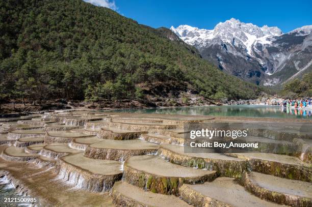 cascading pools at the foothill of jade dragon snow mountain in yulong naxi autonomous county, lijiang, in yunnan province, china. - lijiang stock pictures, royalty-free photos & images