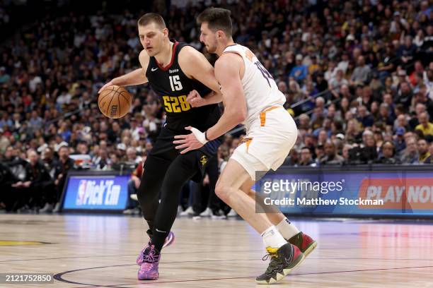 Nikola Jokic of the Denver Nuggets is guarded by Drew Eubanks of the Phoenix Suns during the fourth quarter at Ball Arena on March 27, 2024 in...