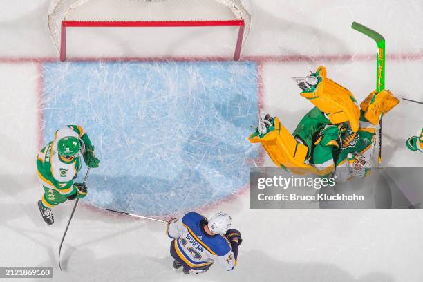 Marc-Andre Fleury makes a save while his teammate Brock Faber of the Minnesota Wild defends against Brayden Schenn of the St. Louis Blues during the...