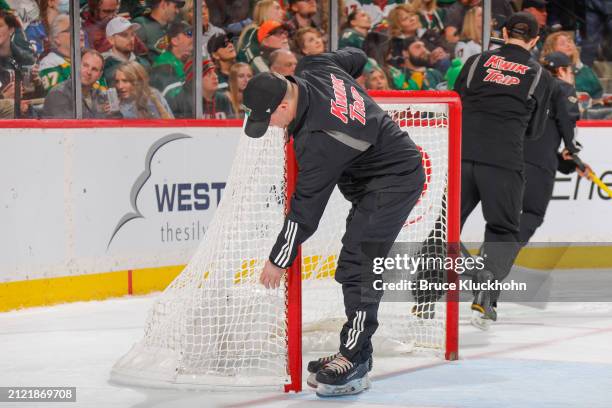 The ice crew inspects the net during the game between the St. Louis Blues and the Minnesota Wild at the Xcel Energy Center on March 23, 2024 in Saint...