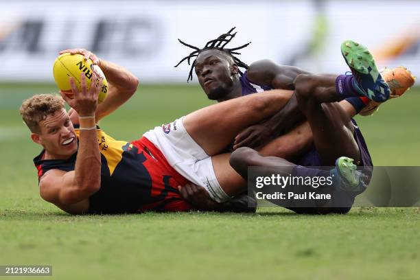 Michael Frederick of the Dockers tackles Mitchell Hinge of the Crows during the round three AFL match between Fremantle Dockers and Adelaide Crows at...