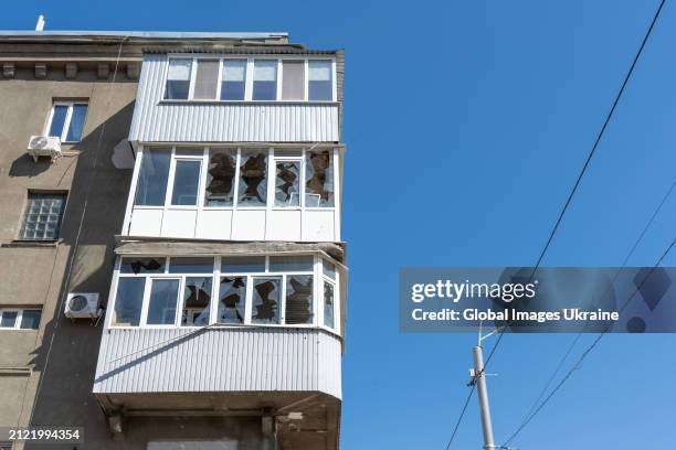 Shattered glass remains in window frames in a residential building damaged because of the strike by Russian kamikaze combat drone in the...